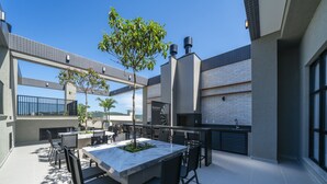 Un'area patio all'aperto con tavolo in marmo, sedie e un piccolo albero.