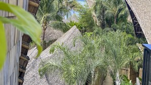 A view from a balcony overlooking a beach with palm trees and a mountain in the distance. - Happiness Kulambo Villa El Nido (El Nido)