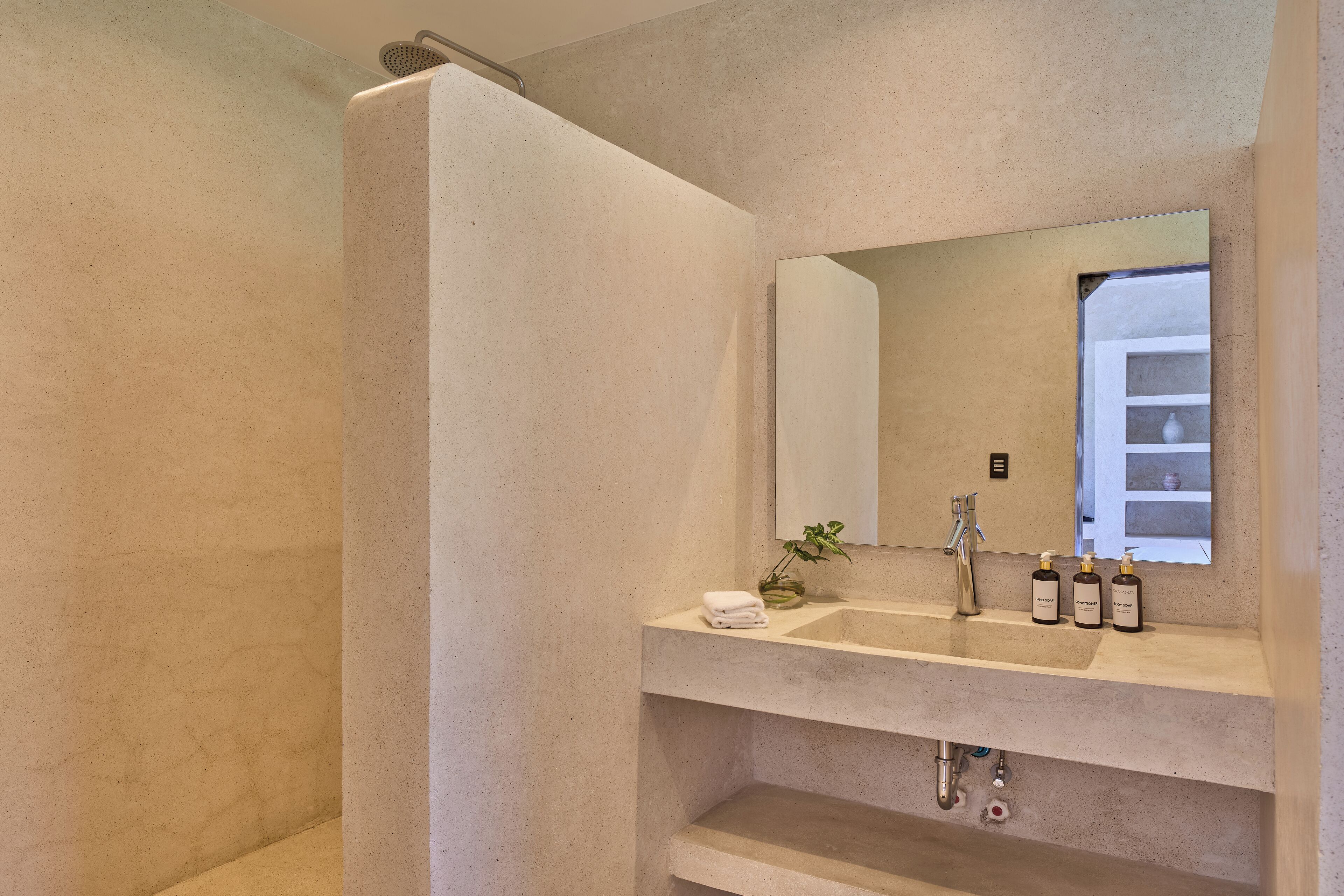 A bathroom with a large mirror, a sink, and a shower.