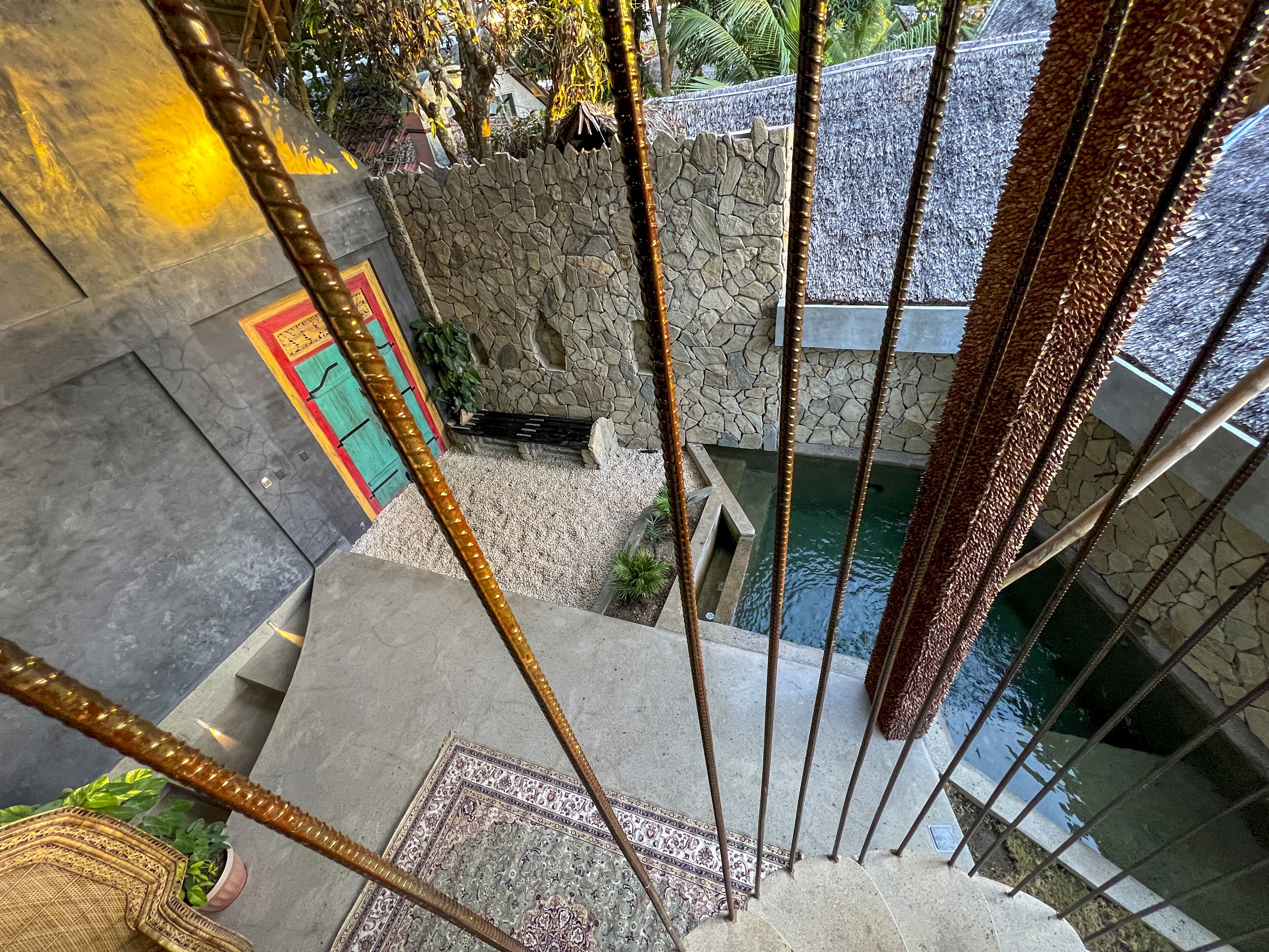 A staircase with a stone wall and a small pool at the bottom.