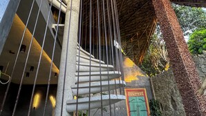 A spiral staircase with a unique design, leading to a green door with a stone wall. - Happiness Kulambo Villa El Nido (El Nido)
