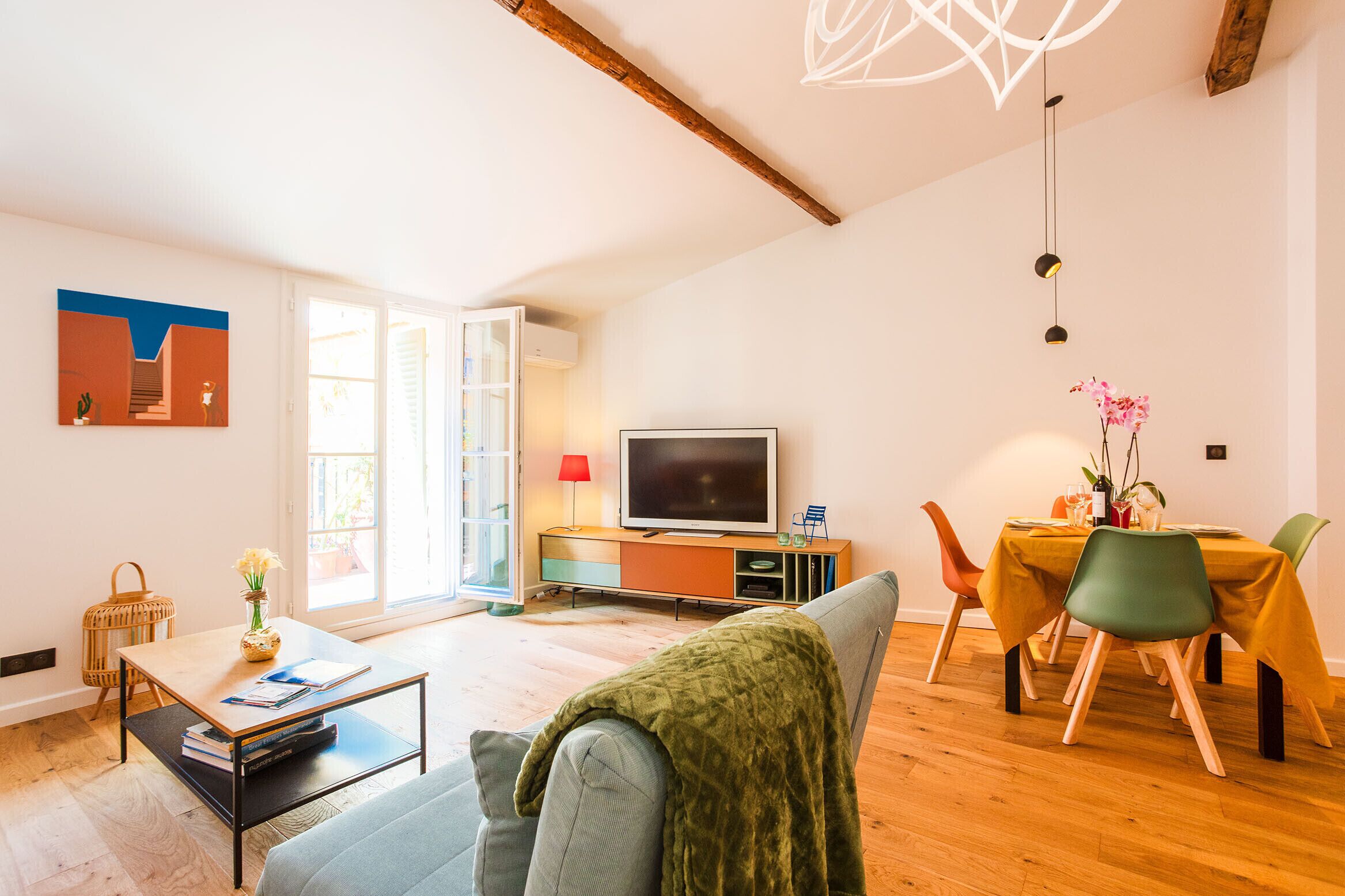 Ein modernes Wohnzimmer mit Sofa, Couchtisch und einem Essbereich mit Tisch und Stühlen.