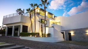 Un bâtiment moderne à deux étages, doté d’un toit plat, d’un balcon et d’un escalier menant à l’étage supérieur.
