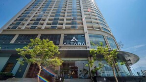 A tall, modern hotel building with a prominent 'ALTARA SUITES' sign. - Luxury 2BR Apartment with Ocean view (Đà Nẵng)