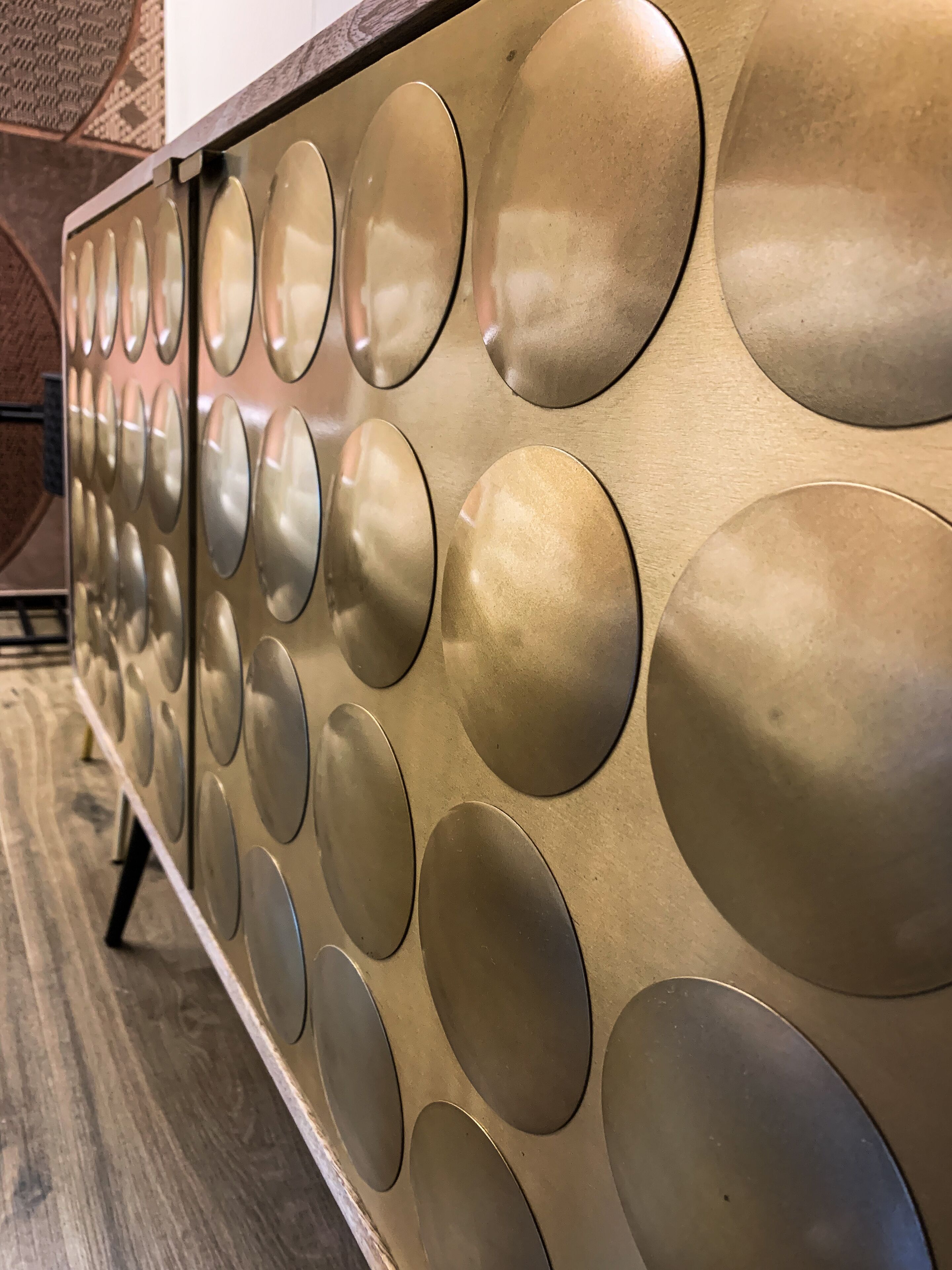 A wall with circular metallic panels.