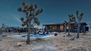 A desert-style house with a pool, outdoor seating, and a fire pit.