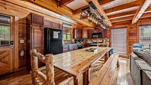 Una cocina rústica de estilo cabaña, con vigas de madera, una isla central y electrodomésticos empotrados.