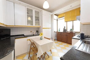 Enjoy dining at the central island with a vase of flowers, surrounded by modern kitchen amenities.