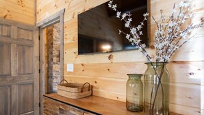 A wooden wall with a mirror, a vase with flowers, and a woven basket on a wooden counter.