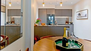 Une cuisine moderne avec un coin repas, comprenant une table avec une bouteille de champagne et des verres.