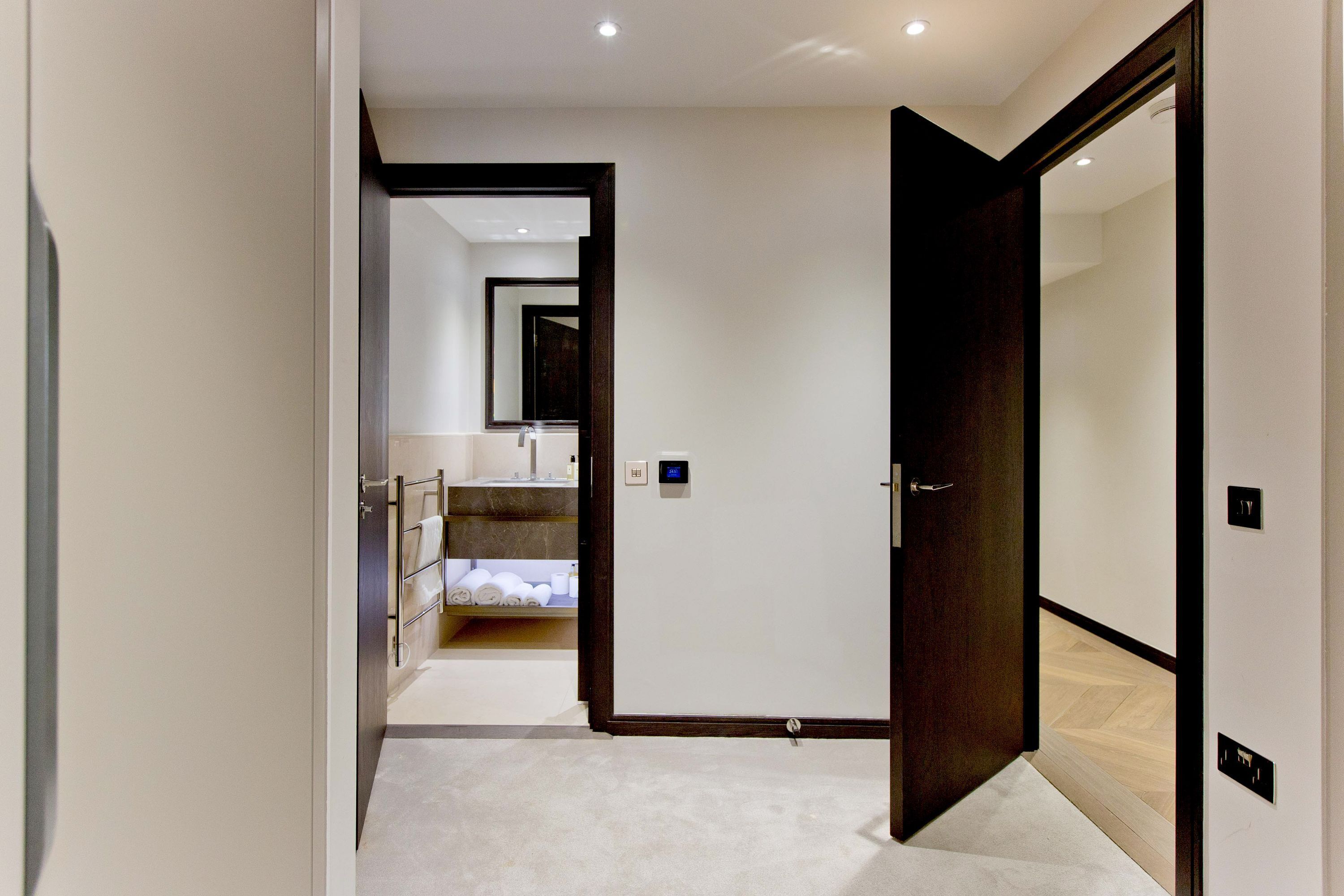 A hotel corridor with a bed, a bathroom, and a reception area.
