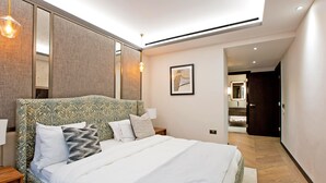 Camera d'albergo moderna con un letto grande, un comodino e uno specchio a muro.