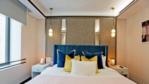 Une chambre d’hôtel bien aménagée, avec un grand lit, des tables de chevet et une fenêtre.