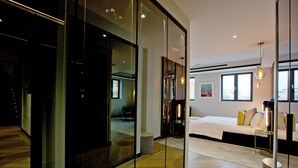 Ett modernt hotellrum med en stor säng, en glasvägg och utsikt över staden.