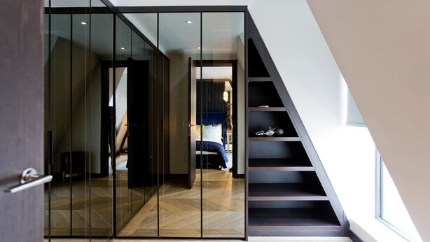 A modern interior with a glass partition, a staircase, and a bed with a blue headboard. - 2-bed Superior Apt 416 (London)