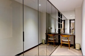 Quarto moderno com divisória de vidro, uma escrivaninha, duas cadeiras e um abajur.