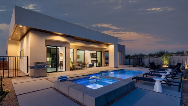 Una casa moderna con piscina, mobiliario exterior y zona de barbacoa.