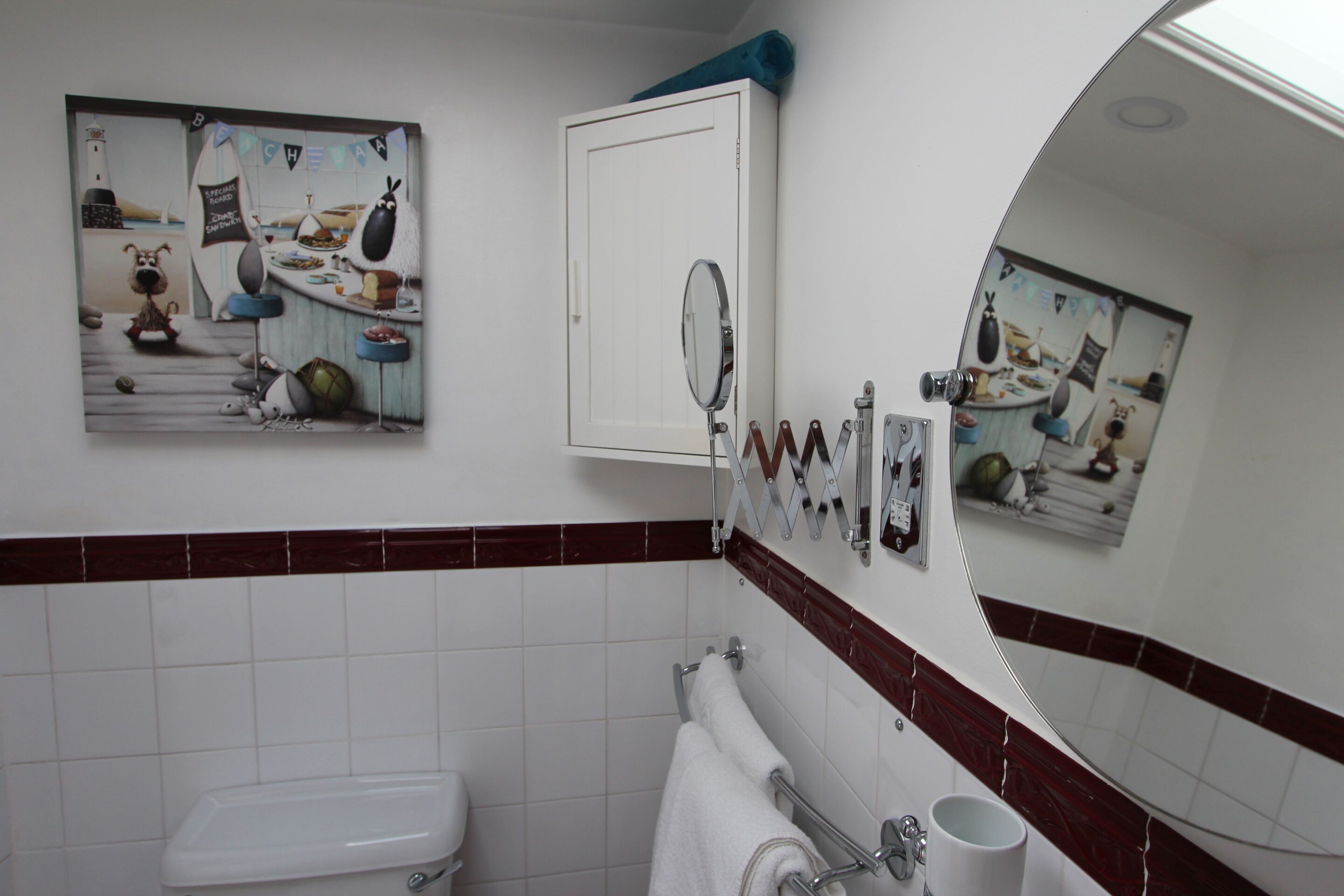 Ein Badezimmer mit Toilette, Waschbecken, Spiegel und Handtuchhalter.