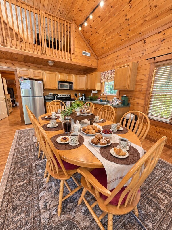 L’intérieur d’une cabane en bois comprend un coin repas, une cuisine et une chambre à l’étage.