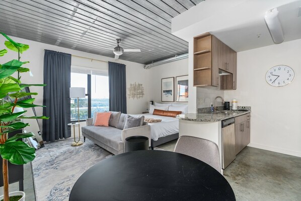 Enjoy a spacious room with a large bed, sofa, and separate dining area, perfect for relaxing and entertaining.
