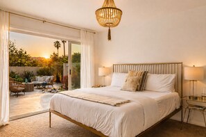 Un dormitorio con una cama grande, dos lámparas de noche, una araña y vistas al exterior.