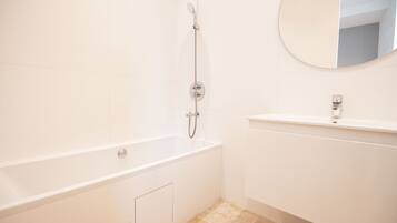 Een douche, handdoeken, zeep, toiletpapier