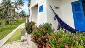 A white building with blue shutters and a hammock. - Pousada Les Alizes (Amontada)