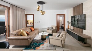 Una sala de estar moderna con un sofá color beige, una mesa de centro redonda y un televisor en la pared.
