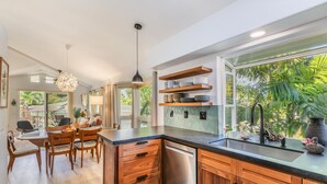 Una cocina moderna con armarios de madera, lavavajillas integrado y un ventanal con vistas al exterior.