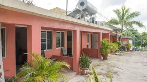 Um edifício com fachada vermelha, várias janelas e um reservatório no telhado.