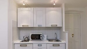 A compact kitchen with white cabinets, a microwave, a kettle, and a sink. - Carla House - Monterosso Cinque Terre .- Citra011019-LT-0135 (Monterosso al Mare)