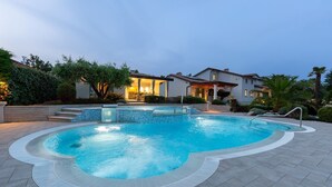 A swimming pool with a hot tub, surrounded by a patio area and a house with a covered outdoor kitchen. - Charming Villa Filton with swimming pool, sauna and jacuzzi (Markovici)