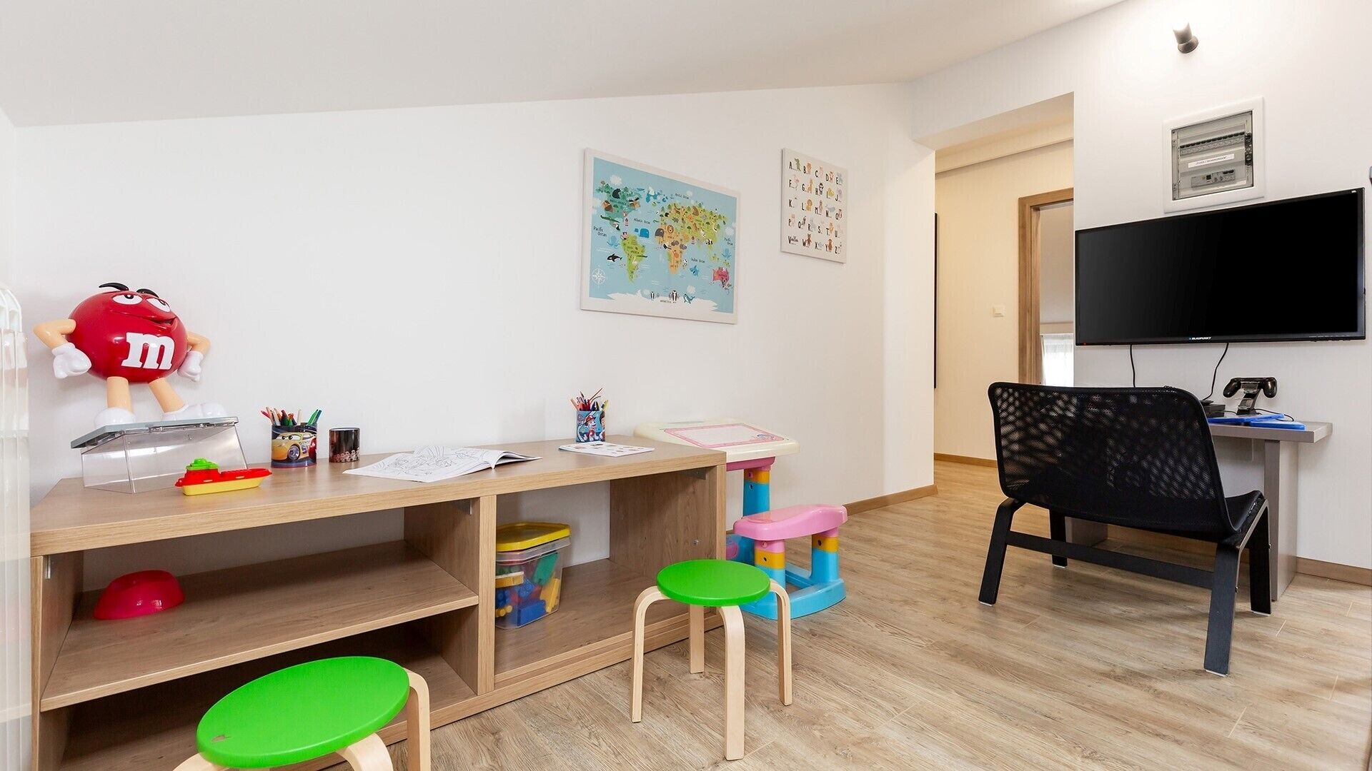 A child's play area with a desk, chairs, and a television.