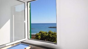 A room with a large window offering a view of the sea and a pier. - Virginia House - CITRA 011019-LT-0354 (Monterosso al Mare)