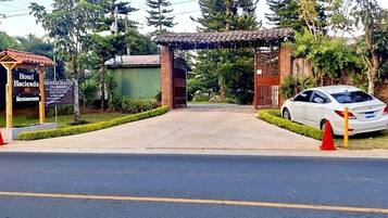 Entrada com portão para um hotel, com sinalização indicando que possui restaurante.