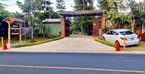 Una entrada porticada a un hotel, con un letrero que indica que tiene restaurante.