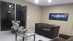 A living room with a sofa, a patterned armchair, and a coffee table. - Smart Cataratas Hotel (Foz do Iguaçu)