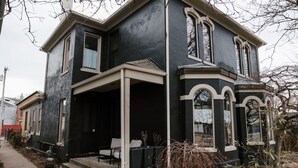 A two-story house with a porch, a small garden, and a pathway leading to the entrance. - Oregon District Oasis - The Best of Downtown (Dayton)