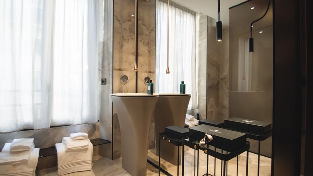 A modern bathroom with a marble sink, two towel stacks, and a large mirror. - Tritone Luxury Suites Fontana di Trevi (Rome)