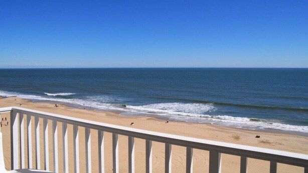 A beach view from a balcony with a railing. - Panoramic Ocean Views | Modern Kitchen|Heated Pool 1304 (Virginia Beach)