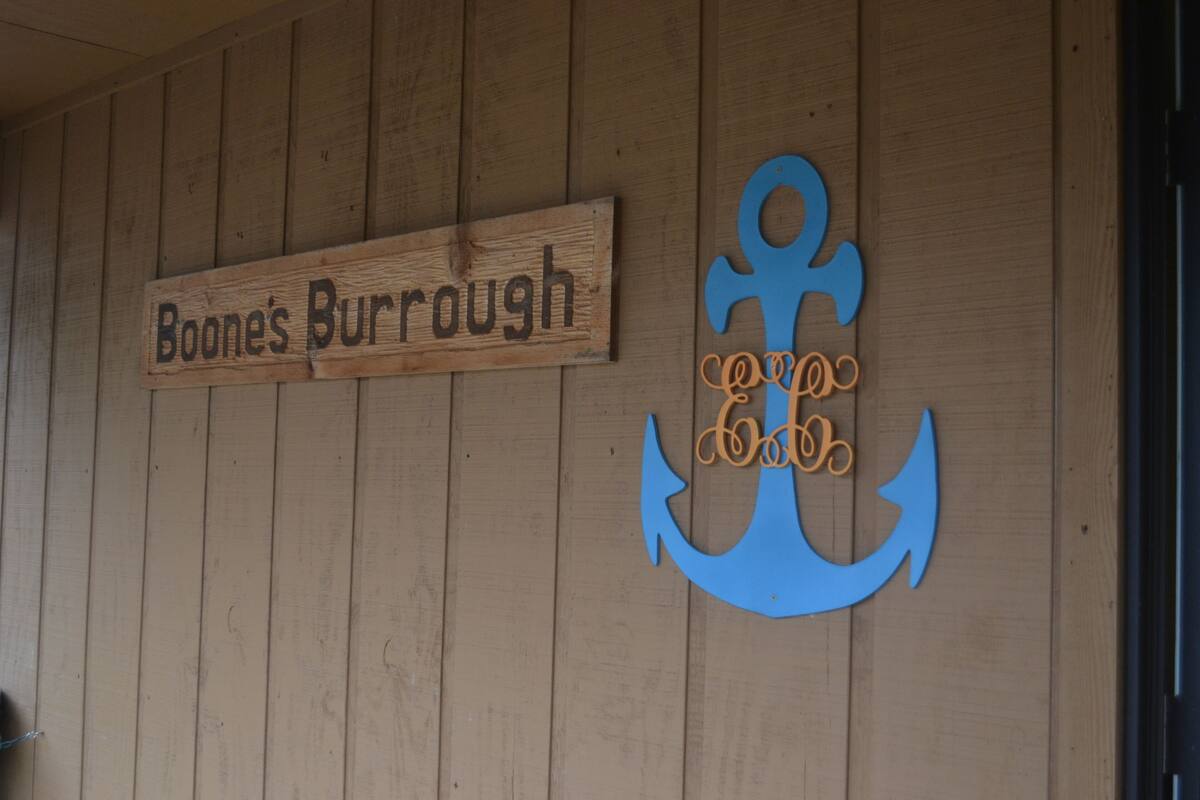 Eine Holzwand mit einem Schild, auf dem 'Boone's Burroughs' steht, und einer blauen Anker-Dekoration.
