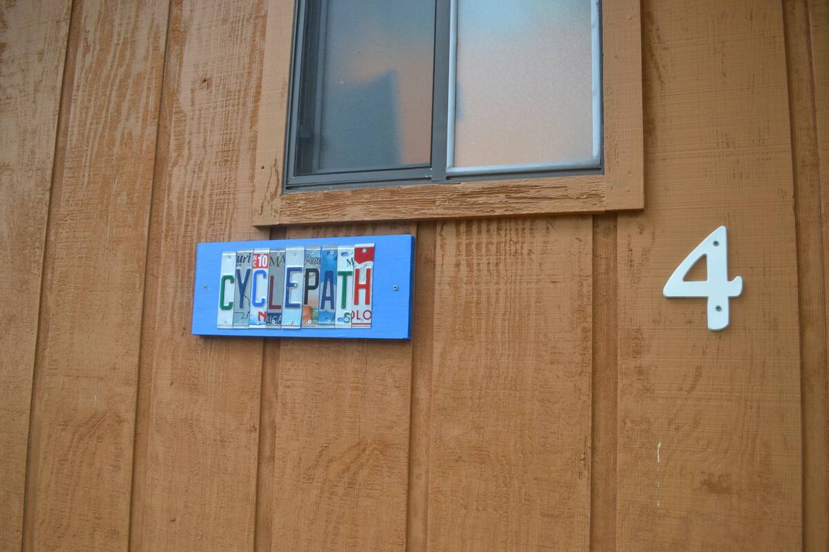Eine Holzwand mit einem blauen Schild, auf dem 