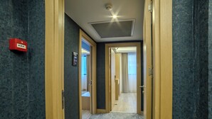 A hallway with wooden doors, a red emergency box, and a ceiling light. - Downtown Sirkeci Hotel (Istanbul)