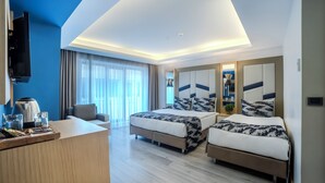 A hotel room with two beds, a desk with a coffee maker, a TV, and a large window with curtains. - Downtown Sirkeci Hotel (Istanbul)