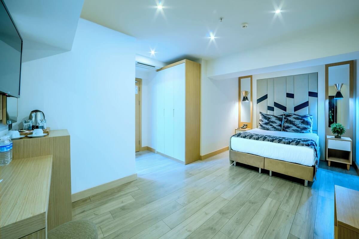 A modern bedroom with a bed, bedside table, and a wardrobe.