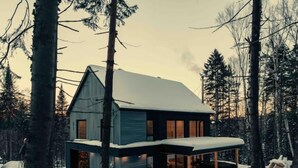 A modern house with a large porch, surrounded by trees and covered in snow. - Au Chalet Calme (Lac-Superieur)
