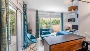A modern hotel room with a bed, a desk, a chair, and a view of the outdoors. - Domaine des Rives D'ormoy : Moorea (Ormoy-la-Rivière)
