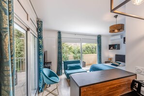 A modern hotel room with a bed, a desk, a chair, and a view of the outdoors. - Domaine des Rives D'ormoy : Moorea (Ormoy-la-Rivière)