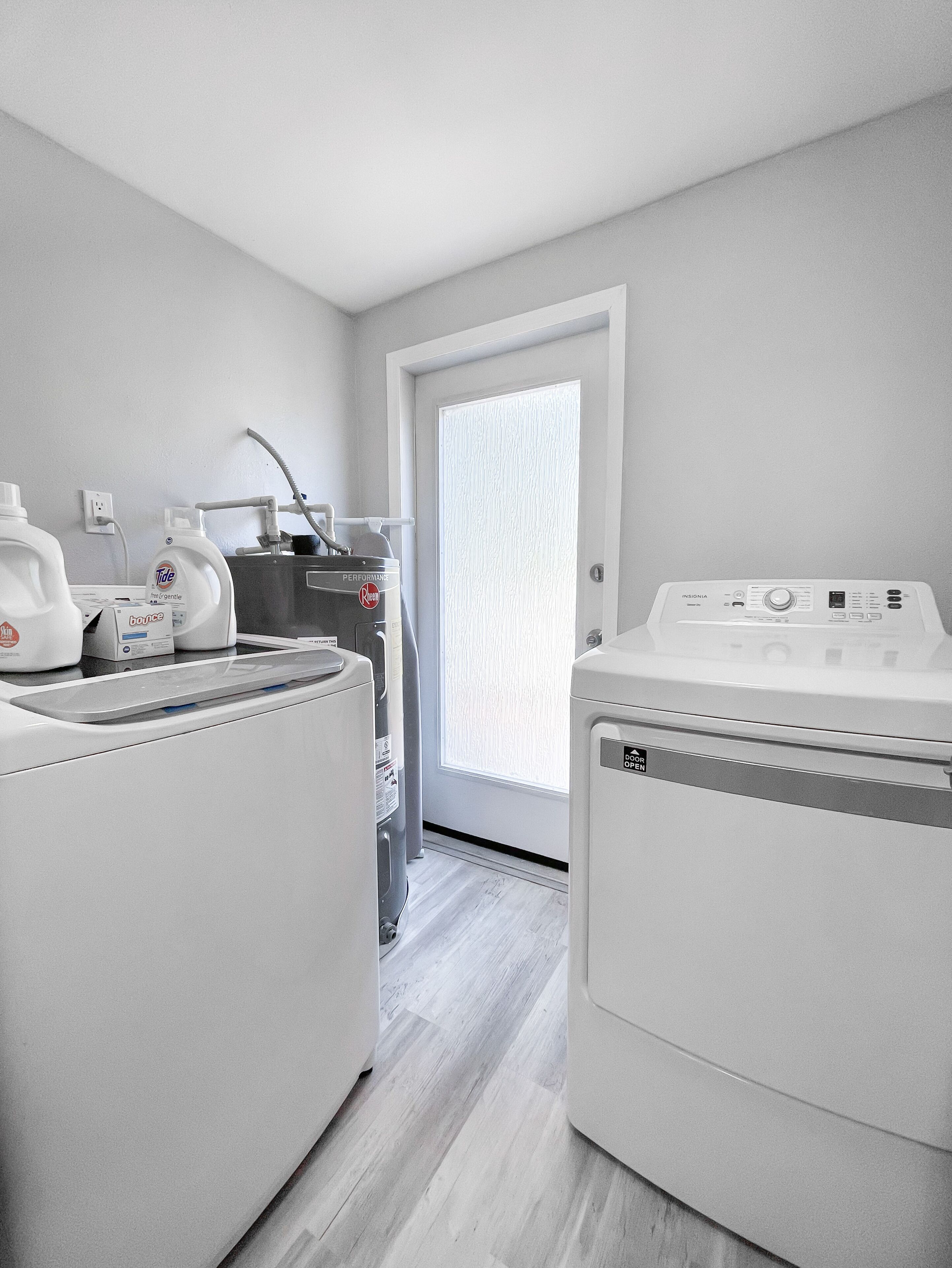 Une buanderie équipée d’un lave-linge, d’un sèche-linge et d’un chauffe-eau.