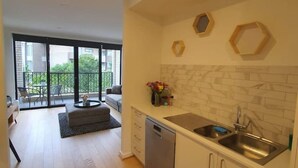 Una cucina moderna con lavastoviglie, lavello e zona pranzo con divano e tavolo.
